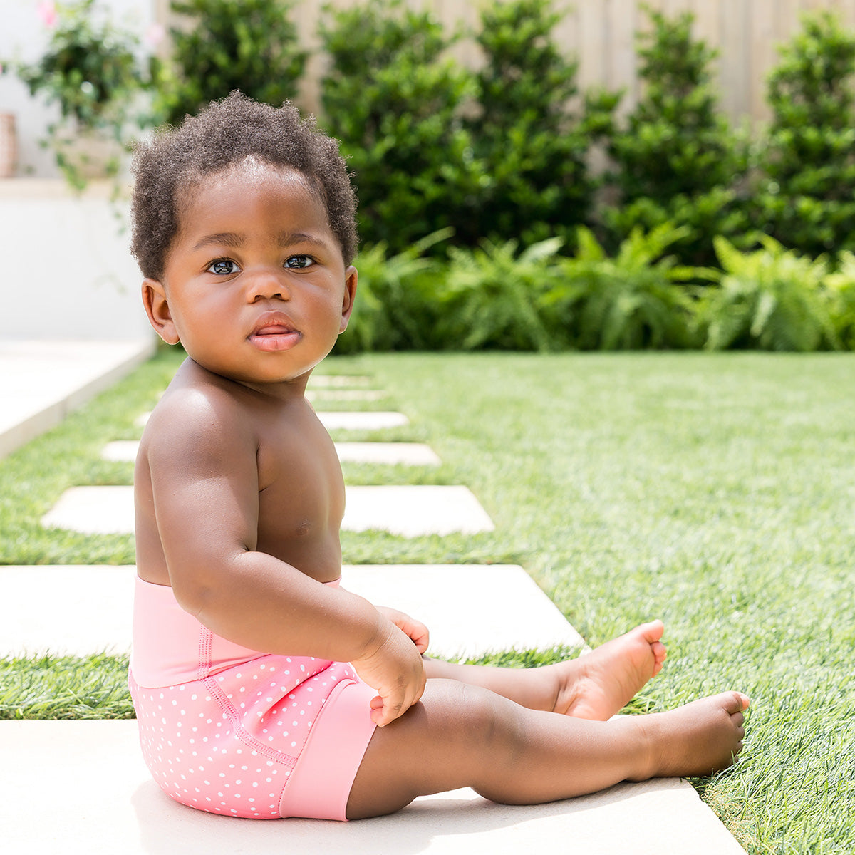 little girl wearing the happy nappy pink dotty reusable swim diaper