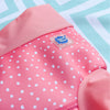 image of the pink dotty happy nappy reusable swim nappy layed on a splash about towel