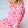close up image of a child wearing the strawberry long sleeve rash top
