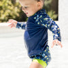 little boy wearing long sleeve rash top turtle tide and matching happy nappy 