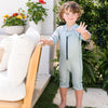 little boy wearing a shorty wetsuit playful otters and waving outdoors
